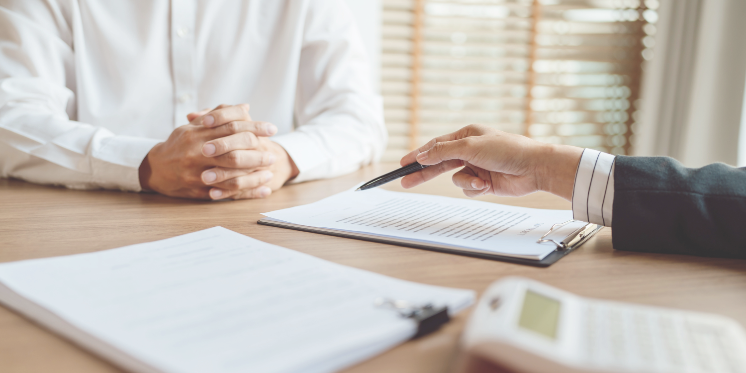 A travel insurance agent explaining paperwork to a client.